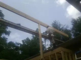 Carpenter setting a ridge beam over a new addition frame — Ice Dam Removal by Roofing Brothers in Melfa
