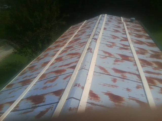 Rusted metal roof panels with new wood purlins before replacement — Storm Damage Roof Repair in Melfa by Roofing Brothers